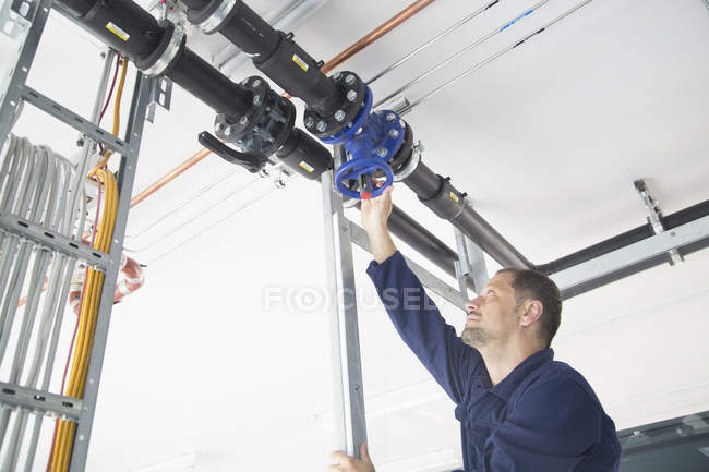 Чоловічий працівник перевіряє кабелі на промисловому заводі — стокове фото