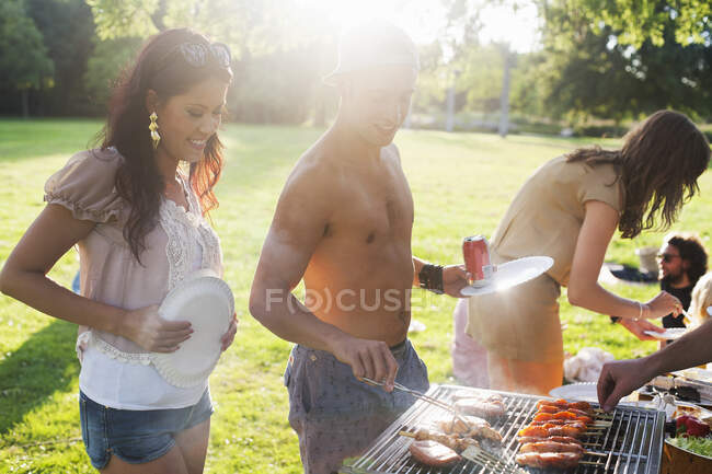 Groupe d'amis barbecue à la fête du parc du coucher du soleil — Photo de stock