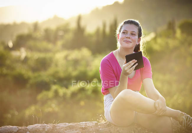 Ragazza adolescente seduta su un muro di pietra con tablet digitale, Maiorca, Spagna — Foto stock