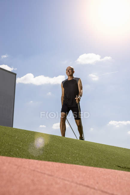 Sportsman walking with hiking pole on field — Stock Photo
