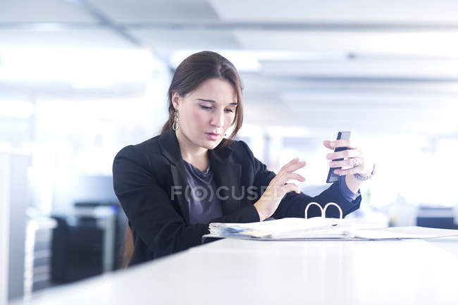 Бізнес-леді за допомогою смартфона в офісі — стокове фото