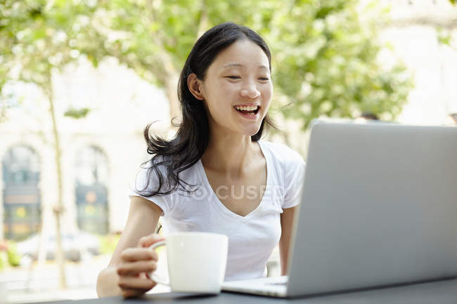 Giovane turista femminile utilizzando il computer portatile al caffè marciapiede, Il Bund, Shanghai, Cina — Foto stock