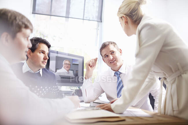 Bürokollegen am Schreibtisch führen Videotelefonate und diskutieren — Stockfoto