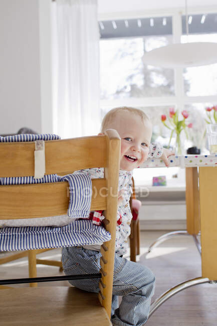 Portrait of female toddler sitting looking over her shoulder — Stock Photo