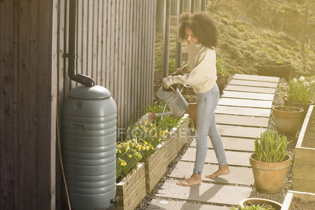 Mid adult woman using watering can — Stock Photo