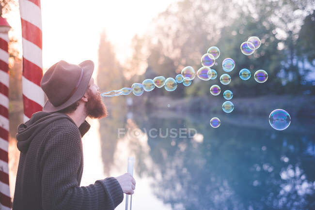 Joven soplando burbujas - foto de stock
