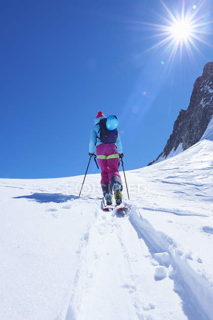 Rear view of mature female skier moving up Mont Blanc massif, Graian Alps, France — Stock Photo