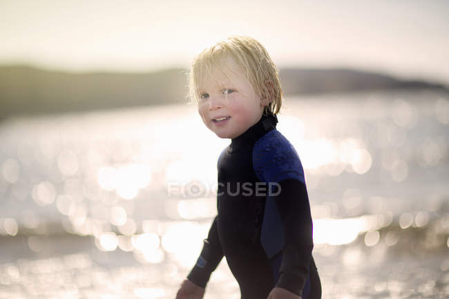 Junge mit nassen Haaren im Neoprenanzug, Portrait — Stockfoto