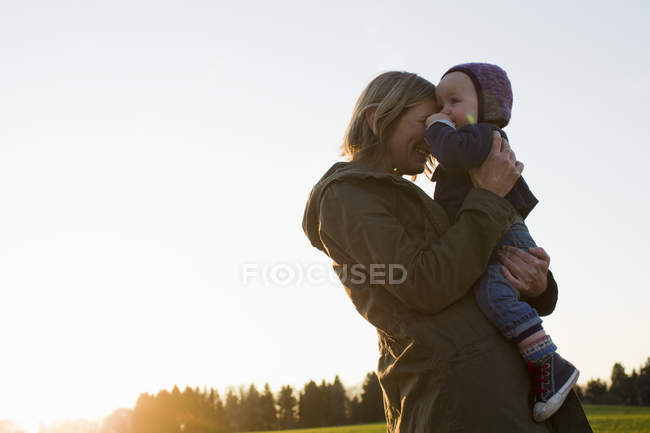 Зріла мати і дочка в полі на заході сонця — стокове фото