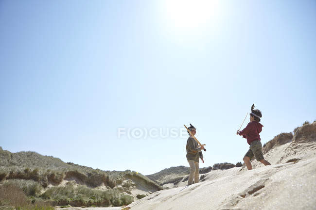 Два мальчика, в маскарадных платьях, играют на песке — стоковое фото