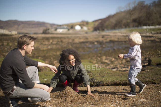 Mãe e pai brincando com o filho, fazendo pilha de solo — Fotografia de Stock