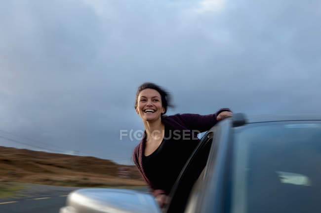 Mulher se inclinando para fora da janela do carro, Connemara, Irlanda — Fotografia de Stock