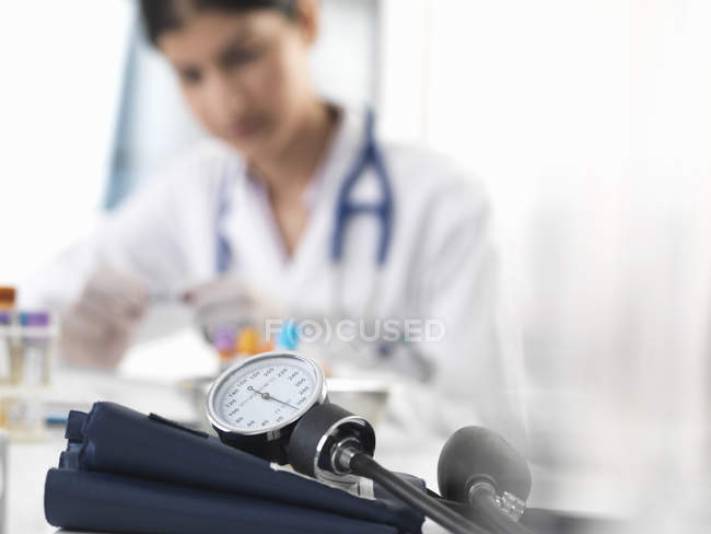 Женщина-врач проверяет образец пробирки на рабочем столе в клинике — стоковое фото