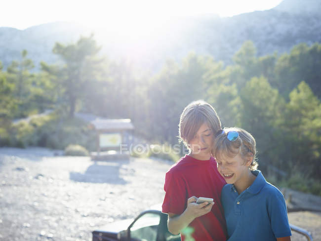 Two brothers looking at smartphone, Majorca, Spain — Stock Photo