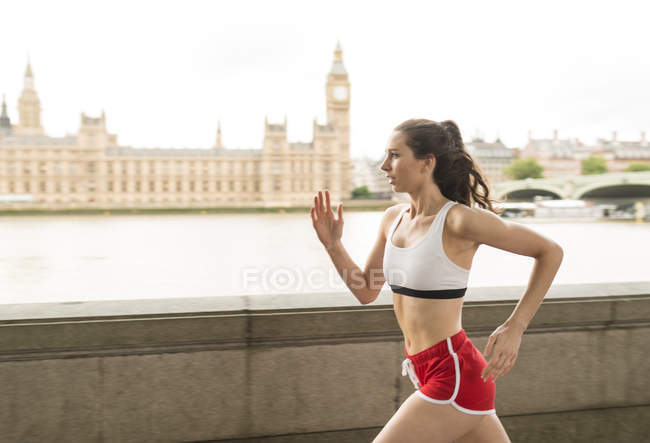 Female runner running along Southbank, London, UK — Stock Photo