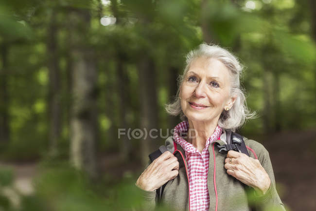 Porträt einer Seniorin, die im Wald steht — Stockfoto
