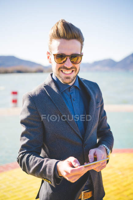 Portrait of young man with digital tablet on lakeside, Rovato, Brescia, Italy — Stock Photo
