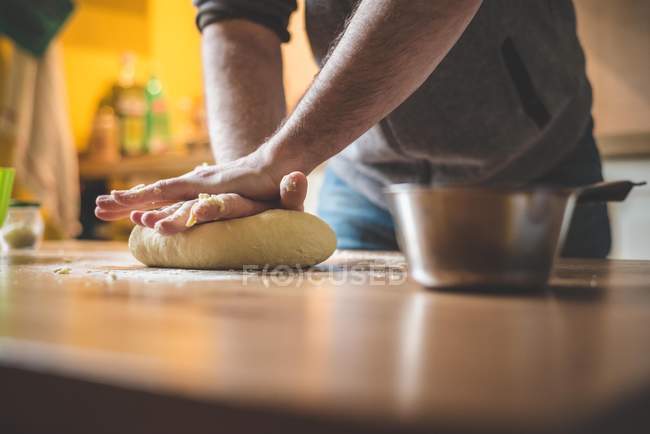 Обрізане зображення людини, що замішує тісто на кухні — стокове фото