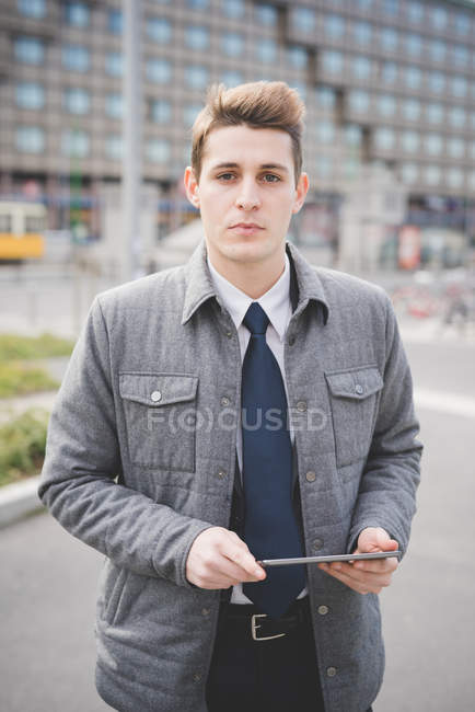 Portrait of young businessman commuter holding digital tablet. — Stock Photo