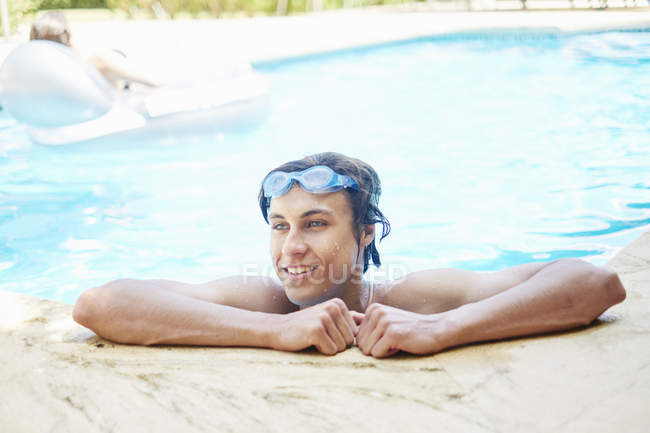 Porträt eines lächelnden jungen Mannes mit nassen Haaren im Schwimmbad — Stockfoto