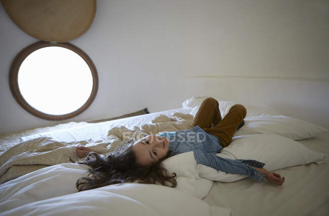 Retrato sincero de menina deitada na cama — Fotografia de Stock