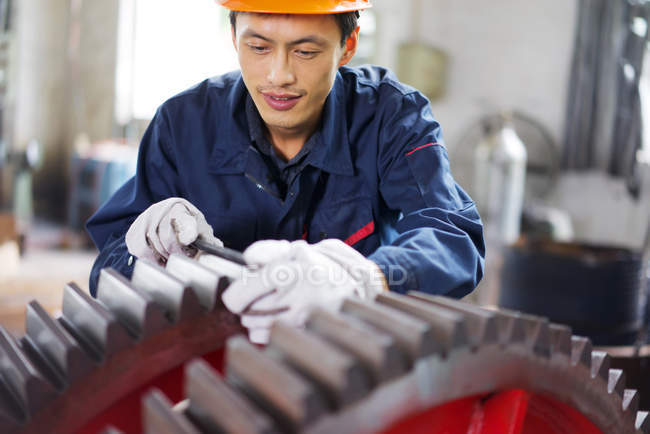 Operaio che utilizza attrezzature in impianto di produzione gru, Cina — Foto stock