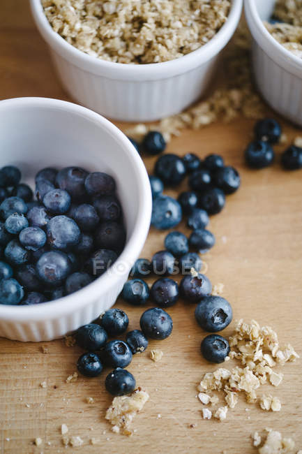 Blueberries in ramekin and on table with crumbs — Stock Photo
