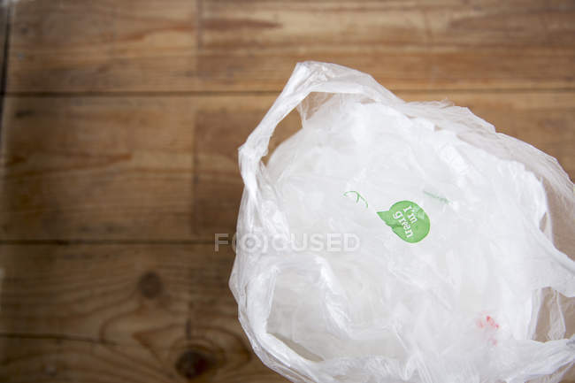 Утилизируемые пластиковые пакеты для покупок на деревянном полу — стоковое фото