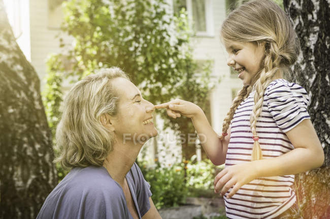 Abuela y nieta jugando juntos en el patio - foto de stock