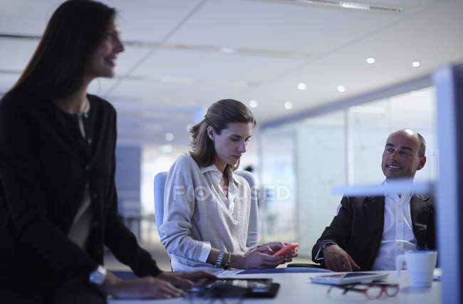 Geschäftskollegen plaudern über Schreibtisch im Büro — Stockfoto