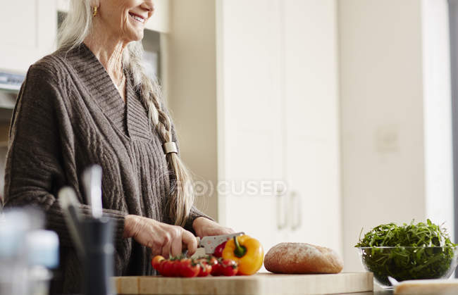 Mulher sênior preparando comida na cozinha — Fotografia de Stock