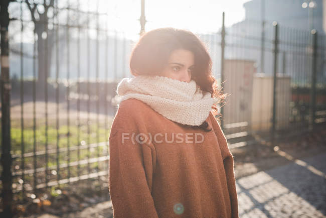 Портрет молодой женщины с шарфом, покрывающим рот в парке — стоковое фото