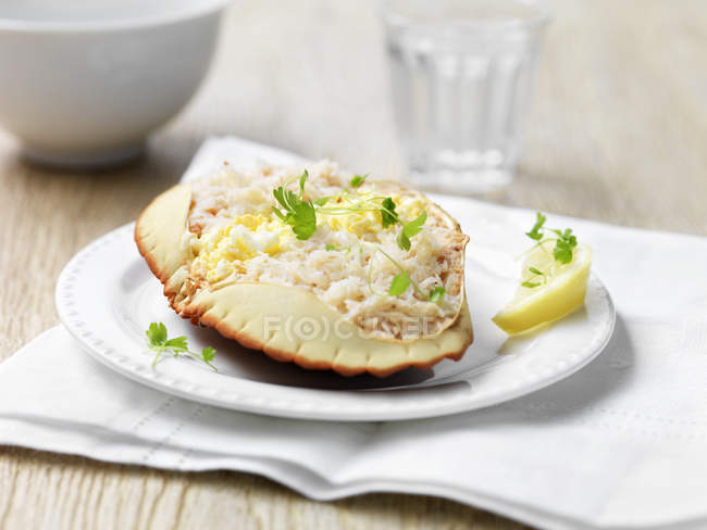 Orkney crab in shell with herbs and lemon wedge — Stock Photo