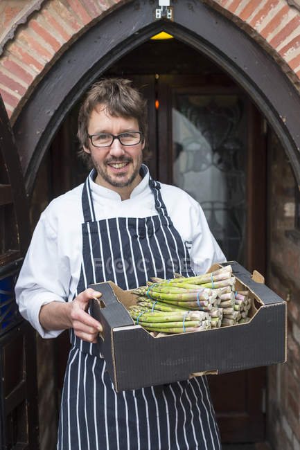 Retrato de chef segurando caixa de espargos — Fotografia de Stock