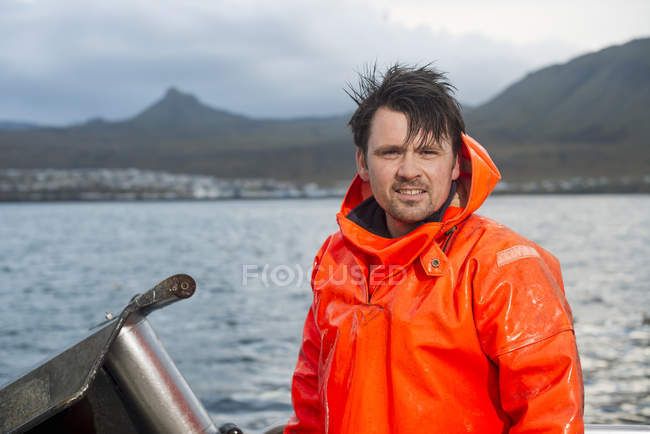 Retrato del pescador mirando la cámara en el barco de pesca - foto de stock