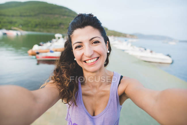Frau an der Küste fotografiert sich selbst — Stockfoto
