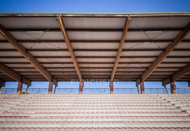 Sièges de stade de sport avec toit en étain contre ciel bleu — Photo de stock