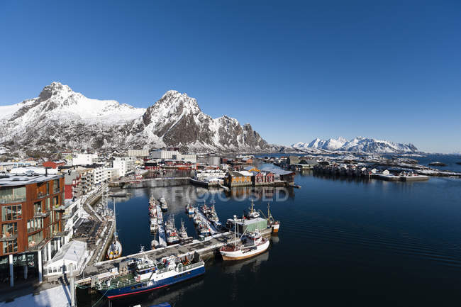 Harbour and snowcapped mountains in bright sunlight — Stock Photo