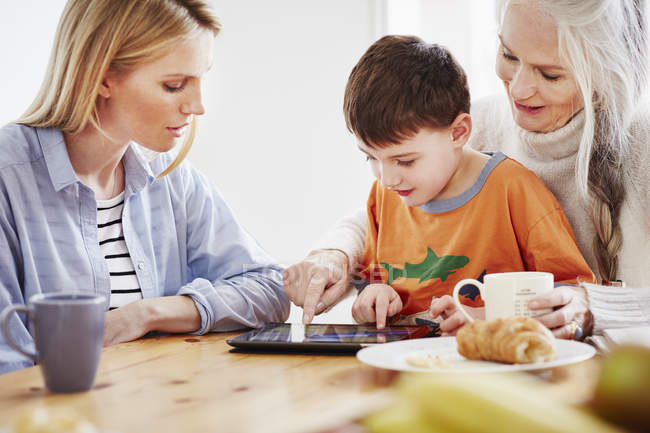 Familia de tres generaciones usando tableta digital - foto de stock