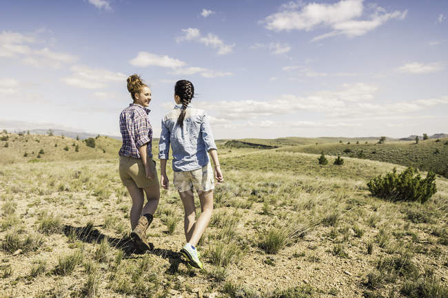 Due giovani donne che camminano sulle colline, Bridger, Montana, USA — Foto stock