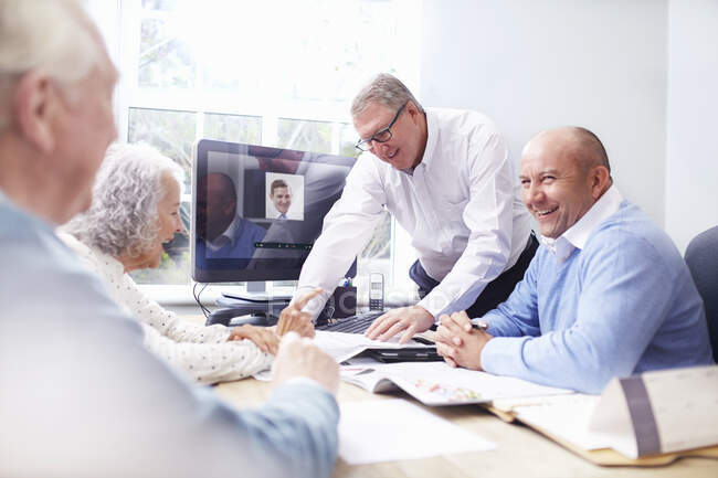 Geschäftsleute im Büro diskutieren mit Senioren-Paar — Stockfoto