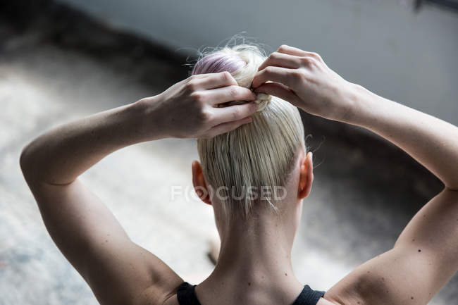 Жінка обв'язує волосся в студії — стокове фото