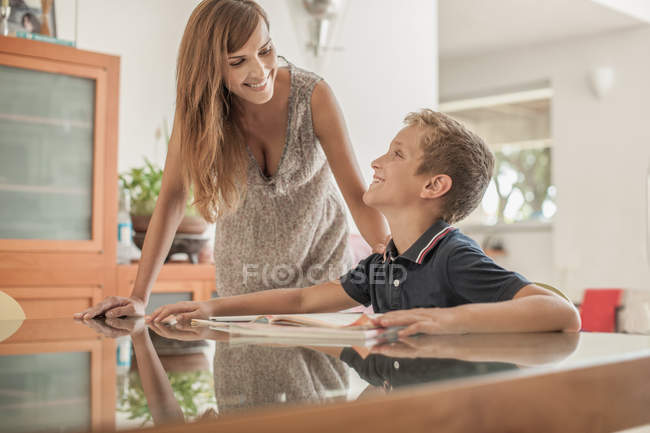 Mãe e filho fazendo lição de casa na mesa da sala de jantar — Fotografia de Stock