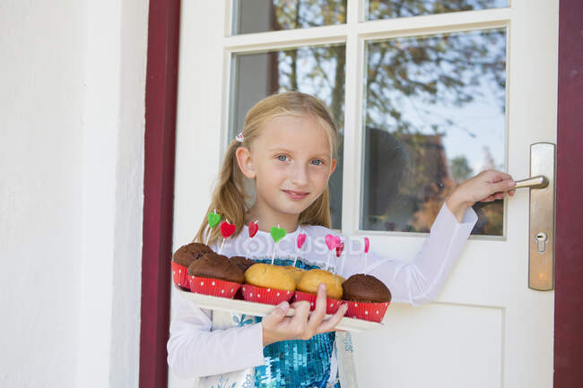 Портрет девушки, несущей торты на патио — стоковое фото