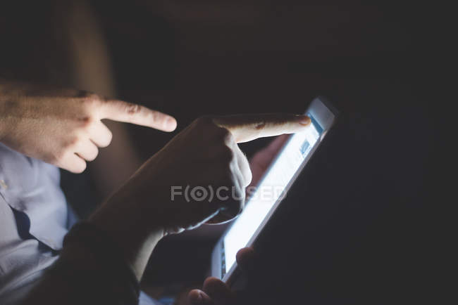 Side view of hands pointing at computer screen — Stock Photo