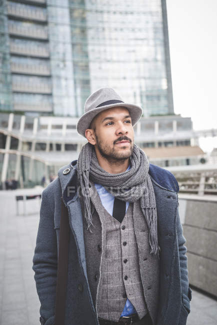 Businessman walking outside city office buildings — Stock Photo