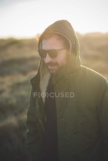 Homem adulto médio vestindo anorak com capuz no campo — Fotografia de Stock