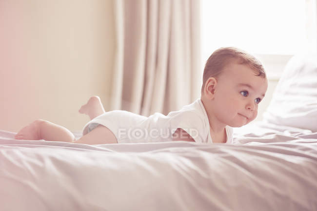 Bambino sdraiato sul letto, concentrazione selettiva — Foto stock