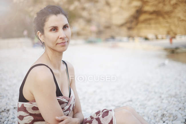 Reife frau sitzt am strand, javea, spanien — Stockfoto