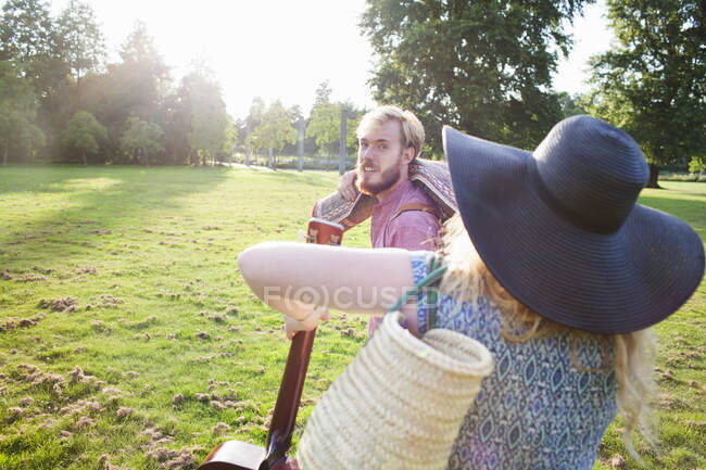 Романтична молода пара, що носить килим для пікніка в парку — стокове фото